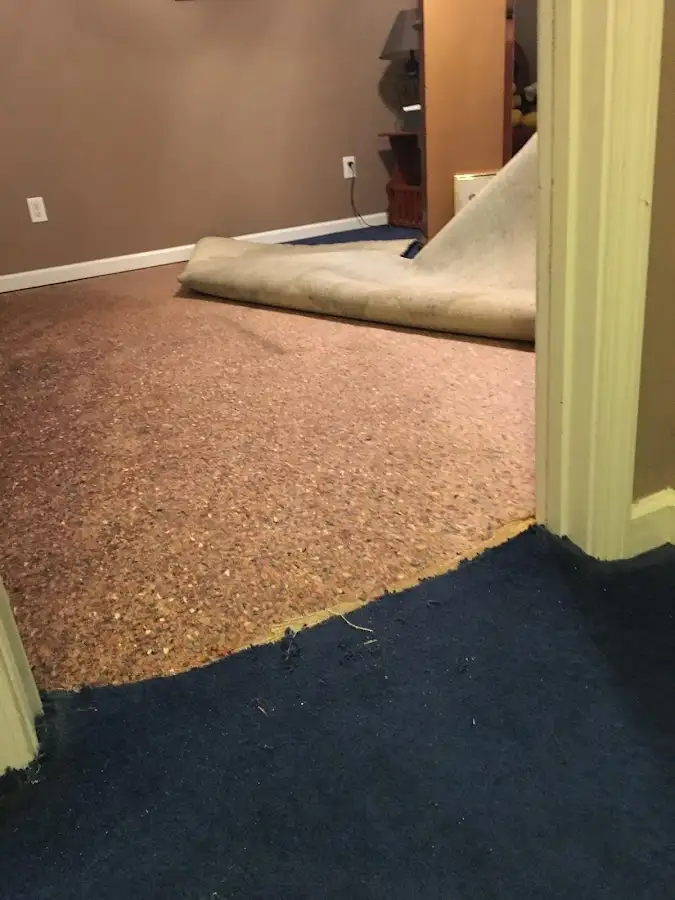 Carpet pad removal revealing water damage during Water Mitigation Services in Two Rivers